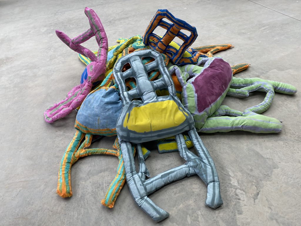 A pile of brightly coloured soft sculptures of the artist's Grandparent's dining chairs